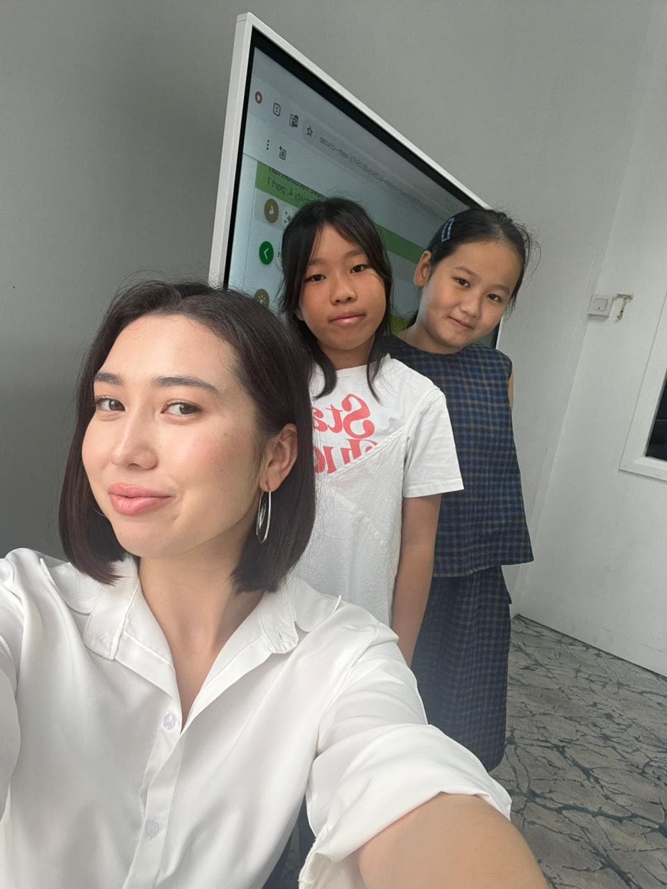 Airim with two students in front of an interactive lesson screen
